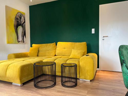 布劳施泰因Gemütliches 3 Zimmer Apartment nahe Science Park的客厅设有一张黄色沙发,配有两张桌子