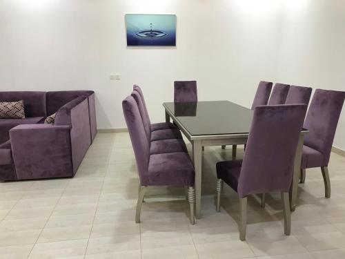 利雅德شاليهات رانديفو العاب مائية مع مسبح的用餐室配有紫色椅子、桌子和沙发