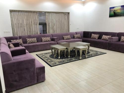 利雅德شاليهات رانديفو العاب مائية مع مسبح的客厅配有紫色的沙发和桌子