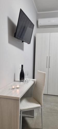 圣费尔迪南多Room's Stromboli的一张桌子、一台电视和两杯酒杯