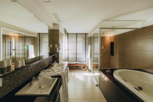 纳塔尔金色郁金香纳塔尔蓬内格拉酒店的大型浴室设有两个盥洗盆和浴缸。