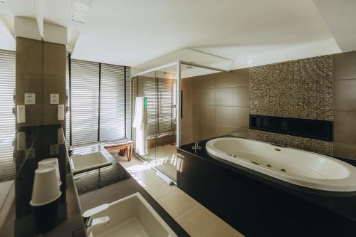 纳塔尔金色郁金香纳塔尔蓬内格拉酒店的一间带大浴缸和水槽的浴室