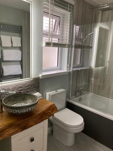 多诺赫Clashmore Wood的浴室配有盥洗盆、卫生间和浴缸。