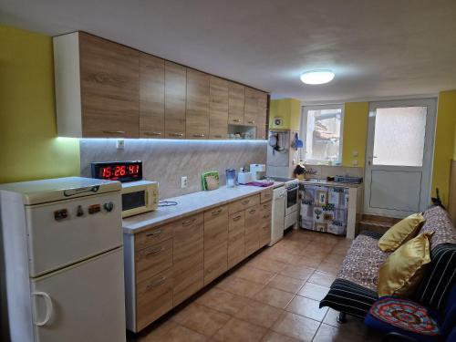 GrammatikovoКъща за гости Пантови的厨房配有木制橱柜和白色冰箱。