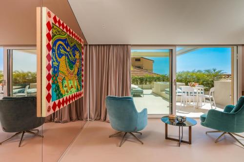 陶尔米纳Taormina Infinity Suites的客厅配有蓝色椅子和大画作