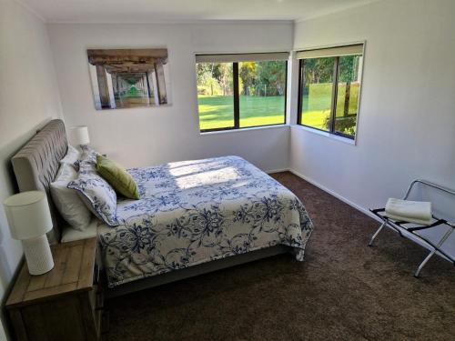 TamaherePalms on Bruntwood的一间卧室设有一张床和两个窗户。