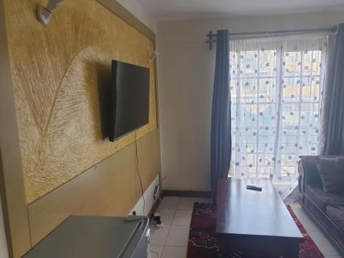 内罗毕Mvuli suites的客厅的墙上配有平面电视。