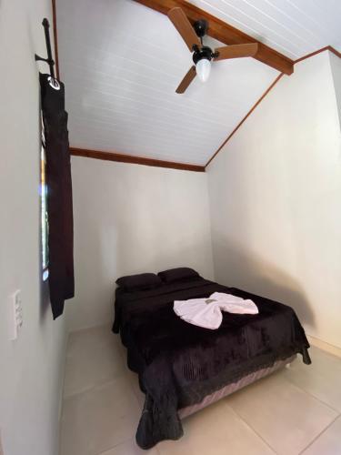 马卡埃Pousada Pedra Grande - SANA的配有吊扇的客房内的一张床位