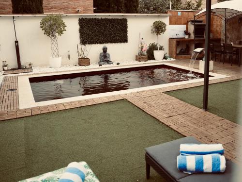 埃斯普卢加·德·隆布雷格Villa Paradise, urban oasis by -Toprentalsbarcelona-的后院的游泳池,有绿色的水