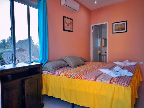 El Paredón Buena VistaHotel el Paredon的一间卧室配有一张带橙色墙壁和窗户的床