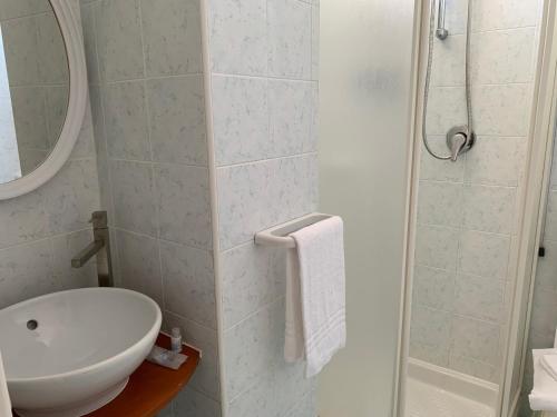 伊斯基亚康特酒店的白色的浴室设有水槽和淋浴。