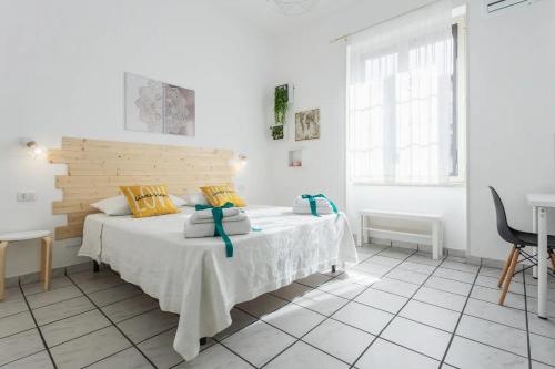 巴勒莫Sophi's house的白色卧室配有一张带木制床头板的床