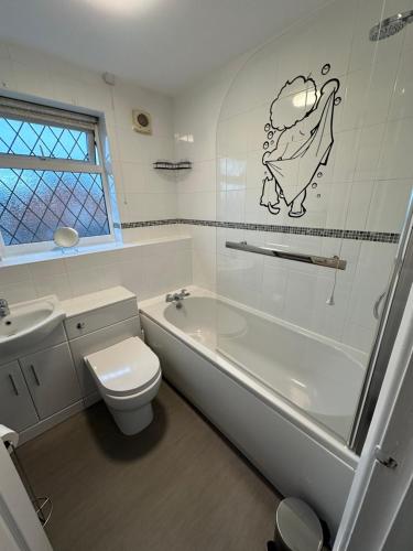 欣克利Hinckley Home Leysmill的浴室配有卫生间、浴缸和水槽。