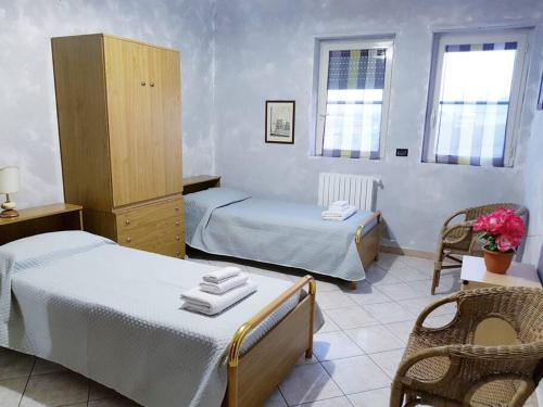 巴列塔Casa ROGGIO的客房设有两张床、一个橱柜和两个窗户。