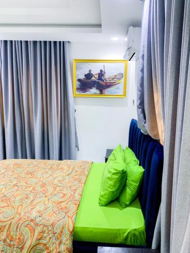 拉各斯60B Adetoun Adelaja 4Bedroom的一间卧室配有一张带绿色搁脚凳的床
