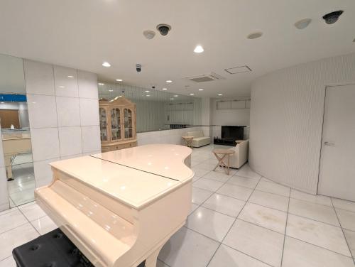 松山瀬戸内リゾートホテル的一间铺有白色瓷砖地板和白色墙壁的大厨房