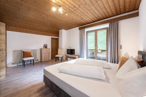 萨尔图西奥圣乌尔苏拉酒店的一间卧室设有一张大床和一个大窗户