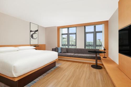 广州广州空港万枫酒店的一间卧室配有一张床、一张沙发和窗户。