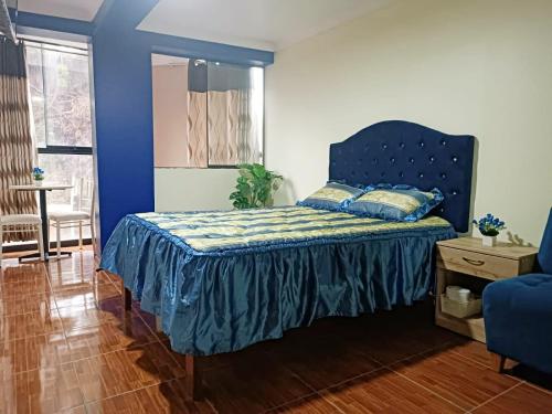 库斯科Munay Wasi CUSCO的一间卧室配有一张蓝色床头板的床