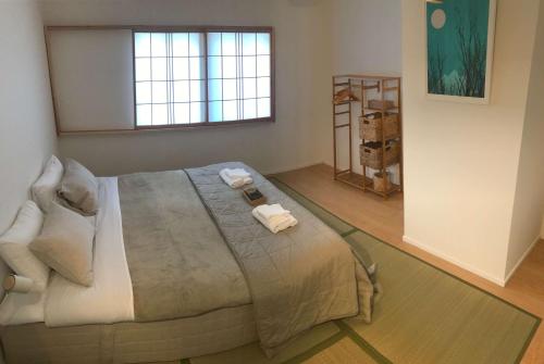 妙高Myoko Forest Lodge的一间卧室配有一张大床和毛巾