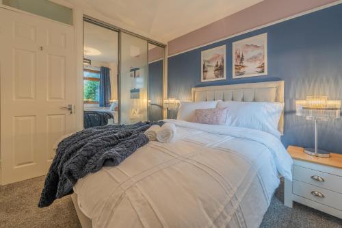 奥尔德姆A Cosy Home from Home的一间卧室配有一张带蓝色墙壁的大床