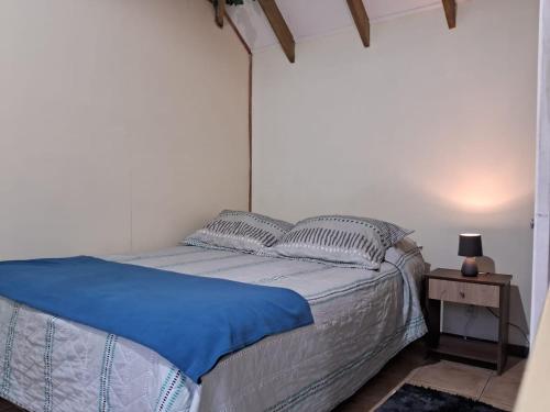 阿尔加罗沃SEA LODGE ALGARROBO的一间卧室配有一张带蓝色床单的床和床头柜。
