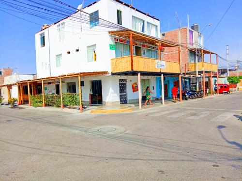 帕拉卡斯HOSPEDAJE WELCOME paracas的一条空的街道,在拐角处有一座白色的建筑