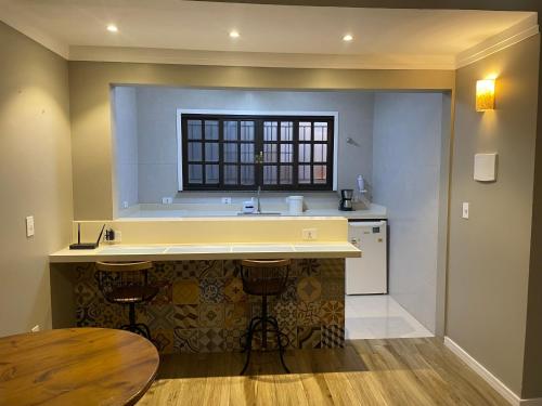 乌巴图巴Chilli Brasil Suite的厨房配有柜台、水槽和桌子