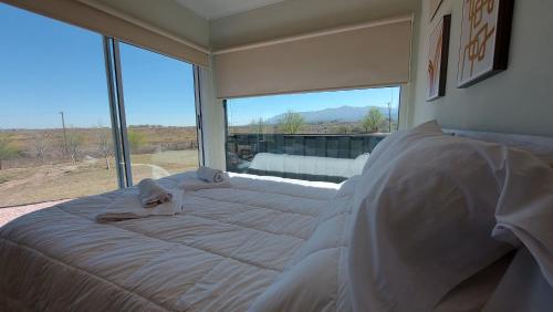 拉库布蕾Son Del Viento的卧室设有一张大床,卧室设有大窗户