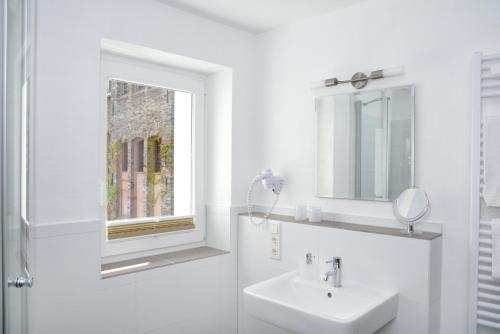贝尔恩卡斯特尔-库斯Rieslinghaus Bernkastel (ehm.Weinhaus Porn)的白色的浴室设有水槽和窗户。