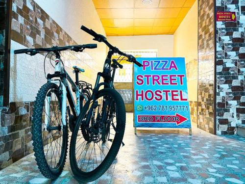 亚喀巴Pizza Street Hostel的停在街医院标志旁的自行车