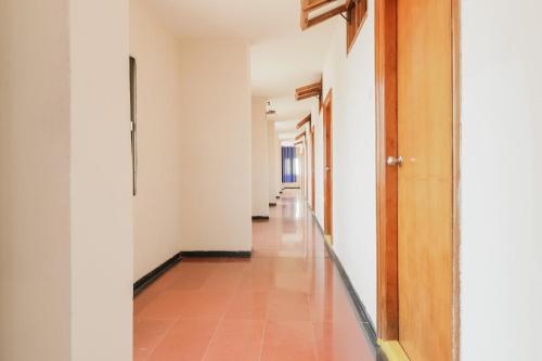 拉加蒙德里OYO Hotel Bommana Residency的一条空的走廊,有白色的墙壁和瓷砖地板