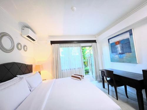 塞米亚克Suite Hotel Apartment Legian by RCP的卧室配有白色的床和书桌