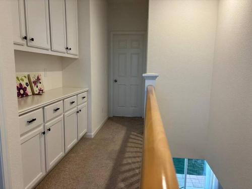 默塞德Cozy Comforting Home的一间厨房,内设白色橱柜和一扇门