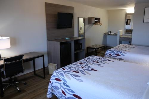 斯汤顿Red Roof Inn Staunton的酒店客房配有一张床、一张书桌和一台电脑