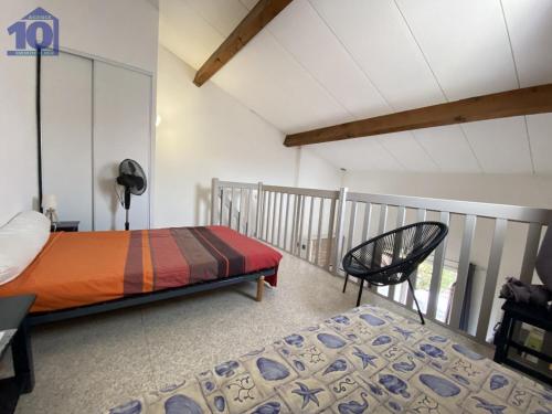 旺德雷Maison Vendres, 2 pièces, 5 personnes - FR-1-781-43的一间带一张床和一把椅子的卧室以及一个阳台