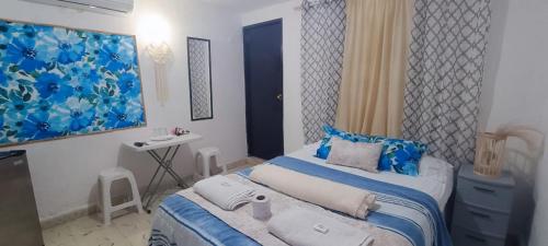 坎昆Casa Calis Cancún的一间卧室配有蓝色和白色床单