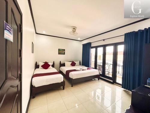万荣Vang Vieng Central Hotel的带窗户的客房内的两张床