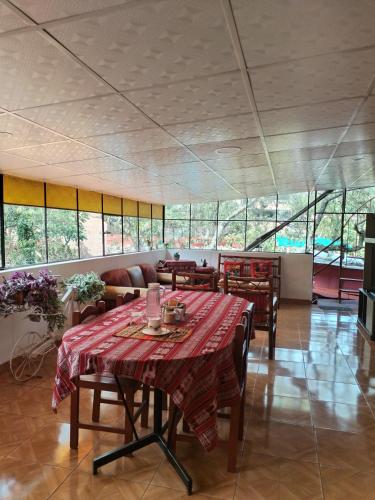 乌鲁班巴Casa familiar Rumichaca的一间带桌椅和窗户的用餐室