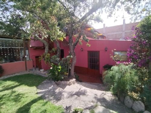 乌鲁班巴Casa familiar Rumichaca的院子里有树的粉红色房子