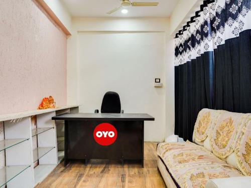 博帕尔OYO Hotel Shivansh的一张桌子,上面有奥普斯标志,在沙发旁边