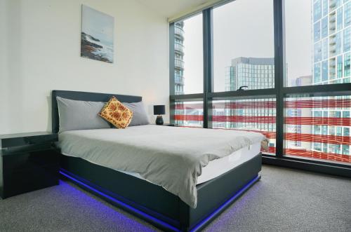 墨尔本Infinity Lux Apartment的一间卧室设有一张床和一个大窗户