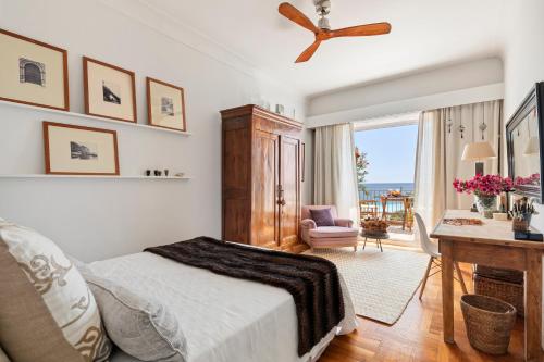 尼斯Unique sea view apartment, center, 100m2的一间卧室配有一张床、一张书桌和一个窗户。