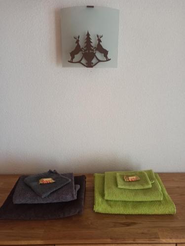 格舍嫩Ferienwohnung Unterdorf的木桌旁的两条绿色毛巾