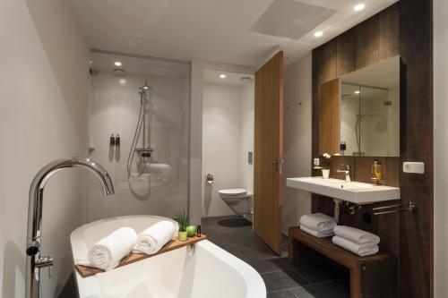 内斯凡赫克伦酒店的带浴缸、盥洗盆和卫生间的浴室