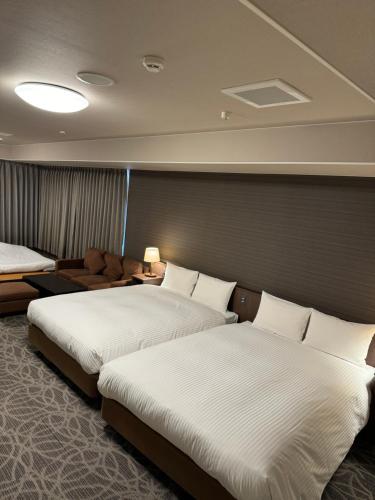 名古屋名古屋合欢树酒店的酒店客房,设有两张床和一张沙发