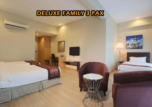 马六甲Ideals Hotel Melaka的一间酒店客房,设有两张床和电视
