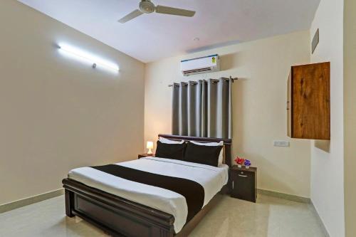 AmeerpetSuper OYO Sri Nirvana Edge的一间卧室配有一张床和吊扇