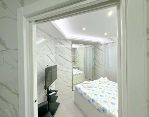 安齐奥Marco House - Seaview Apartment - Anzio的一间带镜子、一张床和电视的卧室