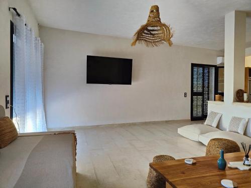 古莱比耶Villa Nour Kélibia的客厅配有沙发和墙上的电视